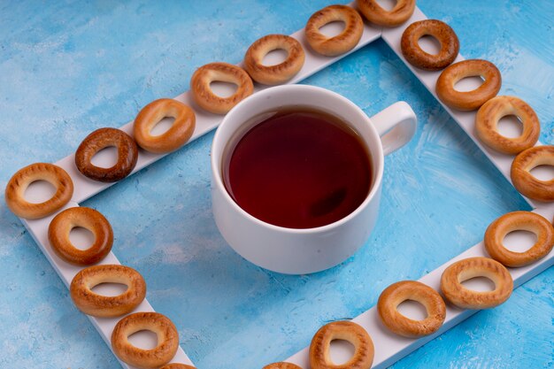 Seitenansicht der russischen Bagels, die mit einer Tasse Tee auf Blau serviert werden