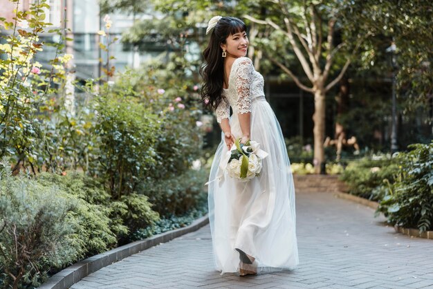 Seitenansicht der schönen Braut draußen mit Blumen