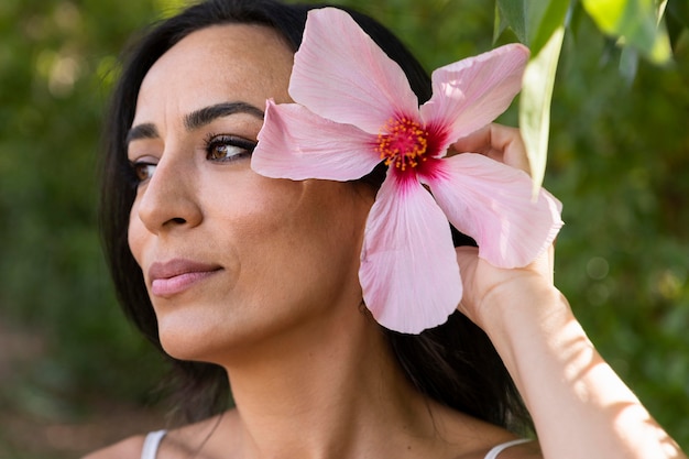 Seitenansicht der schönen Frau im Freien mit Blume im Haar