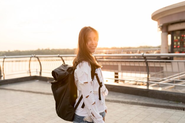 Seitenansicht der Smiley-Frau, die beim Reisen allein aufwirft