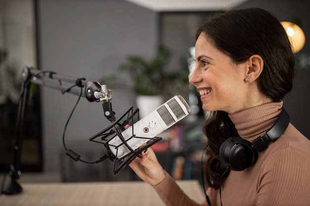 Kostenloses Foto seitenansicht der smiley-frau, die radio tut