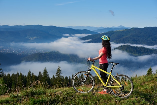 Mann mit dem mountainbike fahren und vom hügel springen