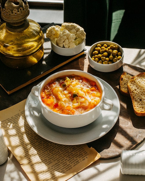 Kostenloses Foto seitenansicht der suppe mit cauiliflower karotte und kartoffeln auf einem holzbrett