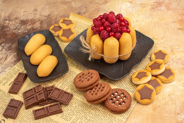 Seitenansicht der verschiedenen Kekse des leckeren Kuchens auf braunem Teller auf gemischter Farbtabelle