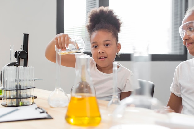 Kostenloses Foto seitenansicht der wissenschaftlerin zu hause, die mit chemie experimentiert