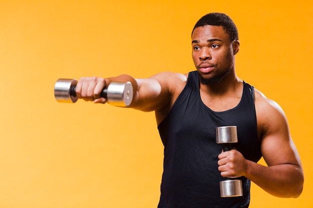 Seitenansicht des athletischen Mannes trainierend mit Gewichten