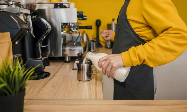 Seitenansicht des Barista, der Milch gießt