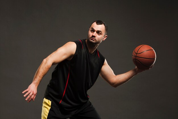 Seitenansicht des Basketballspielers aufwerfend beim Spielen