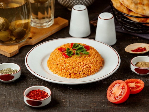 Seitenansicht des Bulgur der türkischen Küche mit Gemüse auf Teller