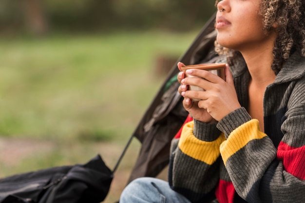 Kostenloses Foto seitenansicht des frauencampings und des heißen getränks