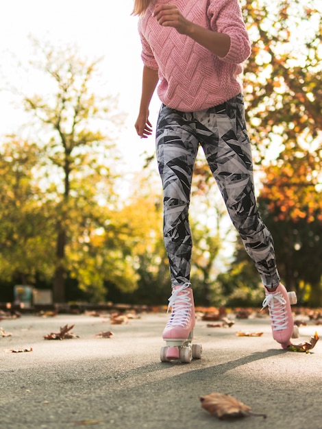 Kostenloses Foto seitenansicht des frauenrollschuhlaufs in den gamaschen