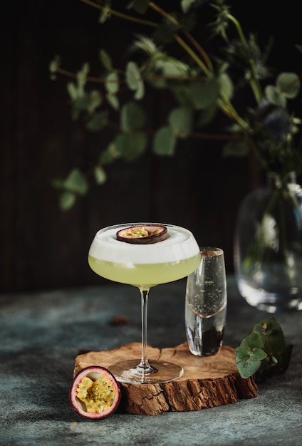 Seitenansicht des frischen tropischen Cocktails mit Passionsfrucht auf einem Holzständer