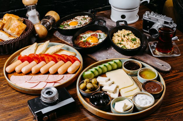 Seitenansicht des Frühstückstisches mit Würstchen frischem Gemüse, Käseschinken und Saucen jpg