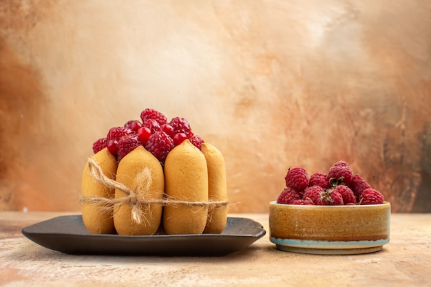 Seitenansicht des gedeckten Tisches mit einem Geschenkkuchen und Früchten für Gäste auf gemischtem Farbtisch