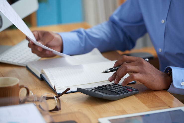 Kostenlose Foto seitenansicht des geernteten mannes arbeitend an finanzbericht