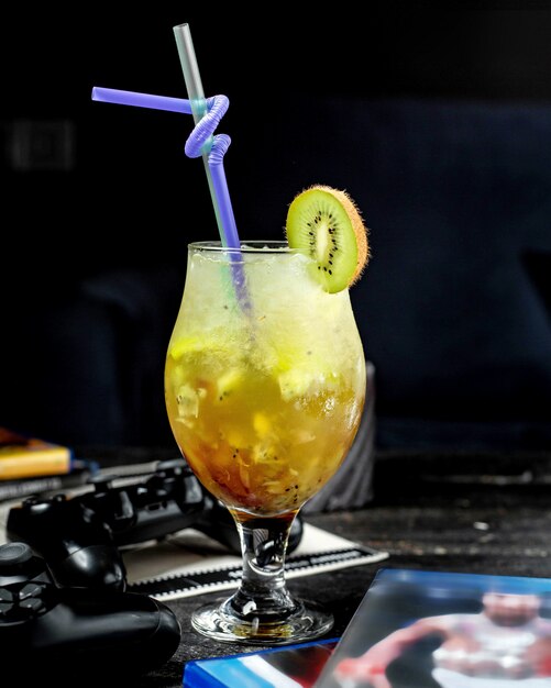 Seitenansicht des gefrorenen Kiwi-Cocktails im Glas auf Dunkelheit