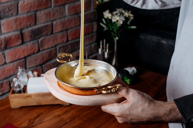 Kostenloses Foto seitenansicht des gießens der kuchenmischung in eine backform