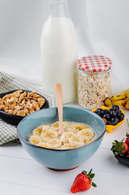 Seitenansicht des Haferbrei mit Banane in einer Keramikschale auf rustikalem Tisch