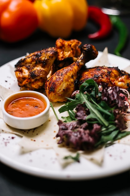 Kostenloses Foto seitenansicht des hühnerkebabs auf lavash, serviert mit frischen kräuterzwiebeln und adjika-sauce