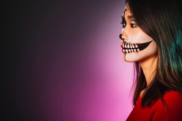 Seitenansicht des jungen Mädchens mit Make-up und Halloween-Maske
