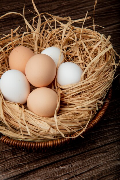 Seitenansicht des Korbes der Eier im Nest auf hölzernem Hintergrund