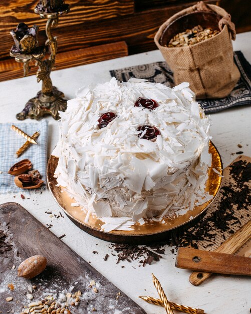 Seitenansicht des Kuchens verziert mit weißen Schokoladenstücken auf dem Tisch