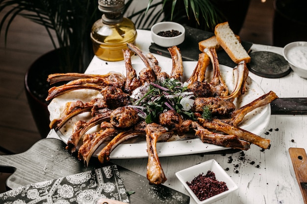 Seitenansicht des Lammkebabs, serviert mit roten Zwiebelkräutern und Sumakh auf dem Tisch