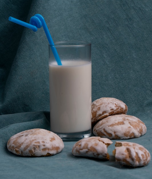 Seitenansicht des Lebkuchens serviert mit einem Glas Milch auf Blau