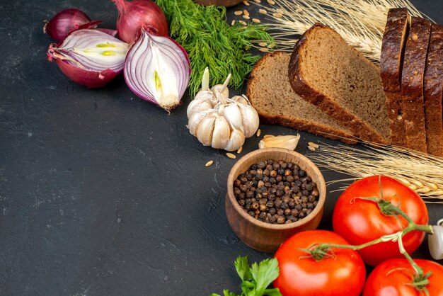 Seitenansicht des leckeren Abendessens Hintergrund grüne Tomaten Brotscheiben Knoblauch auf der linken Seite auf schwarzem Hintergrund