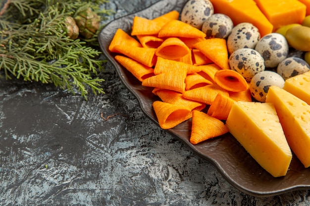 Kostenloses Foto seitenansicht des leckeren besten snacks für wein auf braunem tablett und tannenzweigen auf eishintergrund