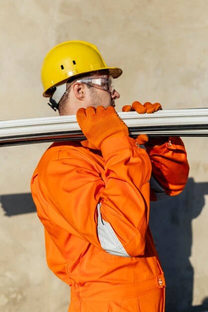 Seitenansicht des männlichen Arbeiters mit Schutzhelm, der Stahl trägt