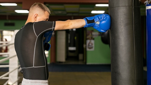 Seitenansicht des männlichen Boxers mit Handschuhtraining