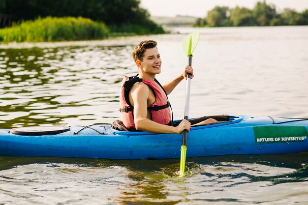 Seitenansicht des männlichen Kayaker, der auf See Kayak fährt