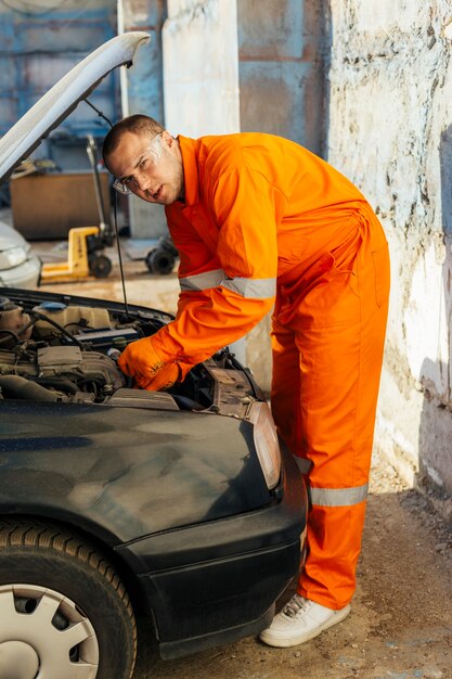 Seitenansicht des männlichen Mechanikers mit Schutzbrille und Uniform