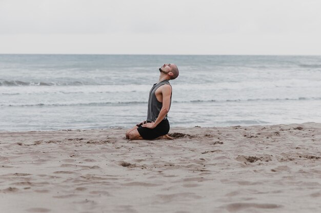 Seitenansicht des Mannes am Strand, der meditiert