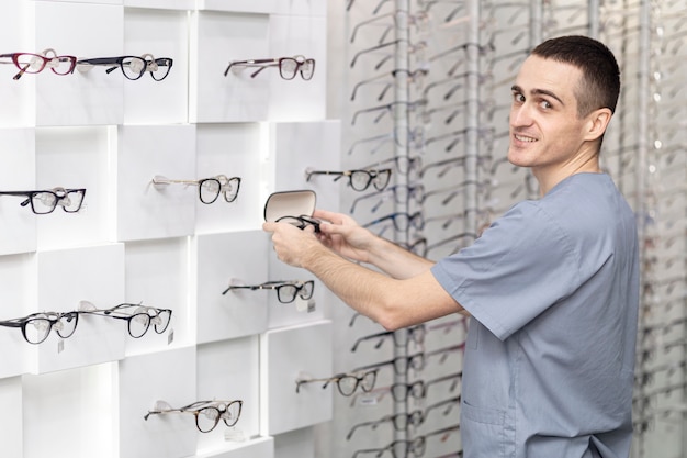 Kostenloses Foto seitenansicht des mannes brille falls setzend