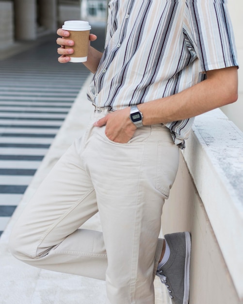 Seitenansicht des Mannes, der draußen mit Kaffee entspannt