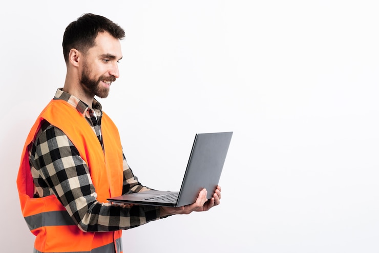 Kostenlose Foto seitenansicht des mannes in der sicherheitsweste, die laptop hält