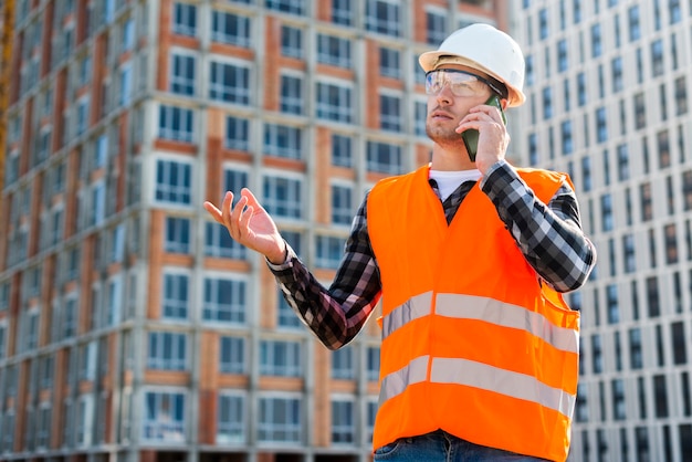 Seitenansicht des mittleren Schusses des Bauingenieurs sprechend am Telefon