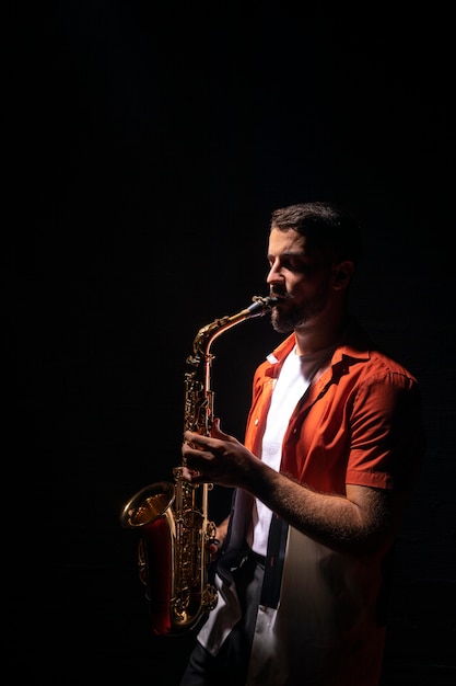 Seitenansicht des Musikers, der Saxophon mit Kopierraum spielt