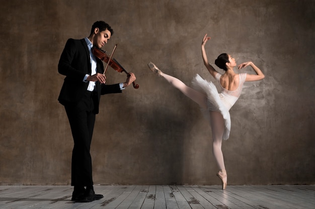 Seitenansicht des Musikers mit Geige und tanzender Ballerina