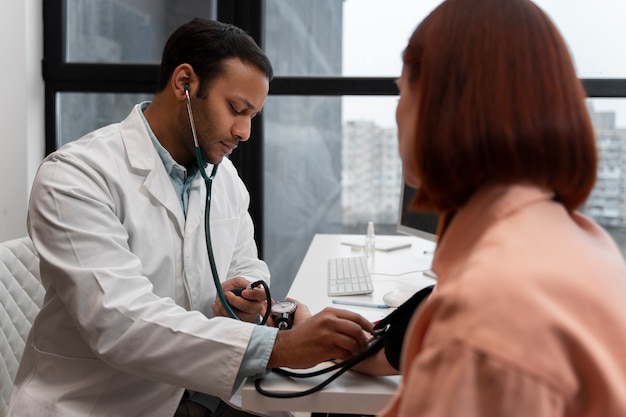 Kostenloses Foto seitenansicht des patienten, der einer körperlichen untersuchung unterzogen wird