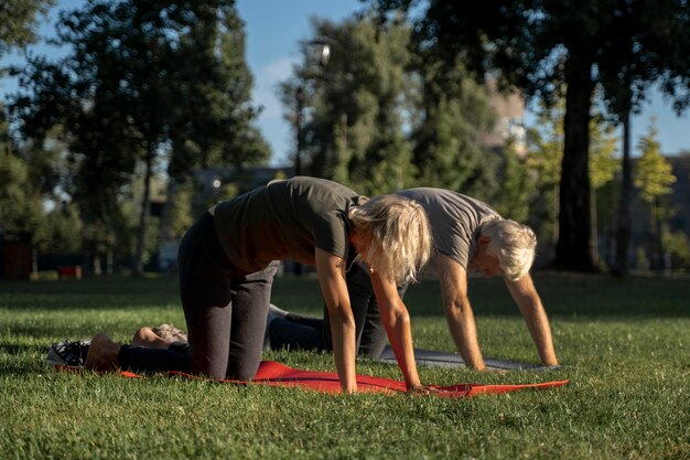 Seitenansicht des reifen Paares, das Yoga im Freien tut