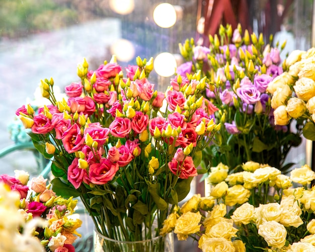 Seitenansicht des rosa Farbspray-Rosenstraußes in der Glasvase