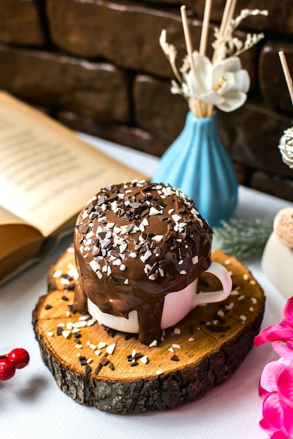 Seitenansicht des Schokoladenpuddingkuchens mit Schokoladenstreuseln in einer Tasse auf einem Holzbrett