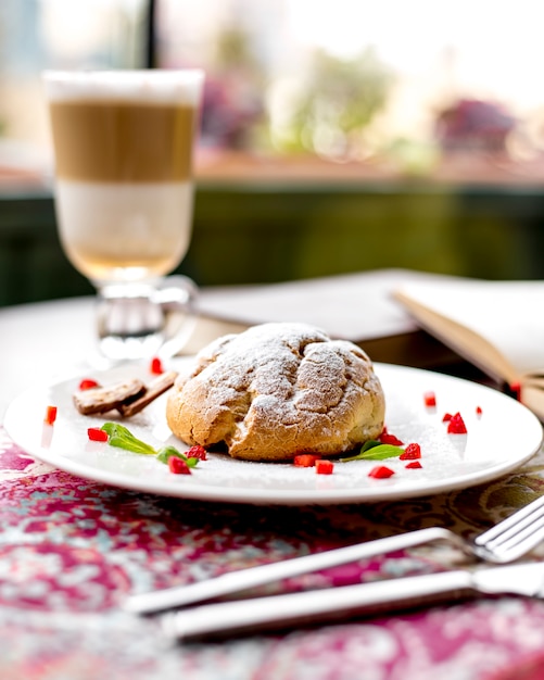 Kostenloses Foto seitenansicht des shortbread-teigkuchens verziert mit geschnittenen erdbeeren auf einem weißen teller