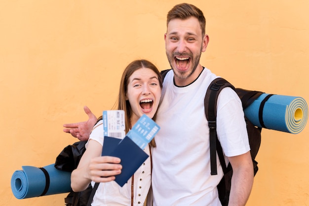 Kostenloses Foto seitenansicht des smiley-touristenpaares mit flugtickets und pässen