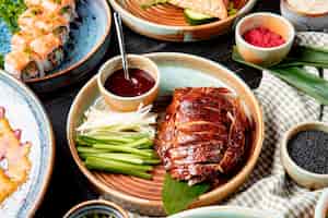 Kostenloses Foto seitenansicht des traditionellen asiatischen essens peking ente mit gurken und soße auf einem teller