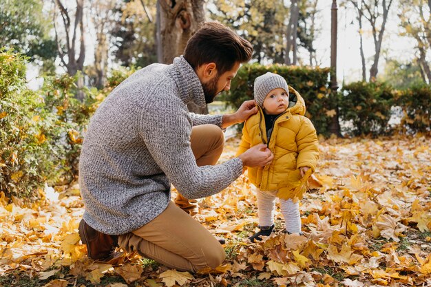 Seitenansicht des Vaters, der Zeit mit seinem Baby draußen verbringt