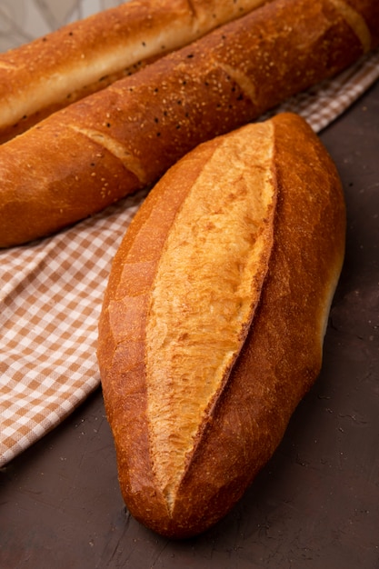 Seitenansicht des vietnamesischen Baguettes mit französischen auf Stoff auf kastanienbraunem Hintergrund